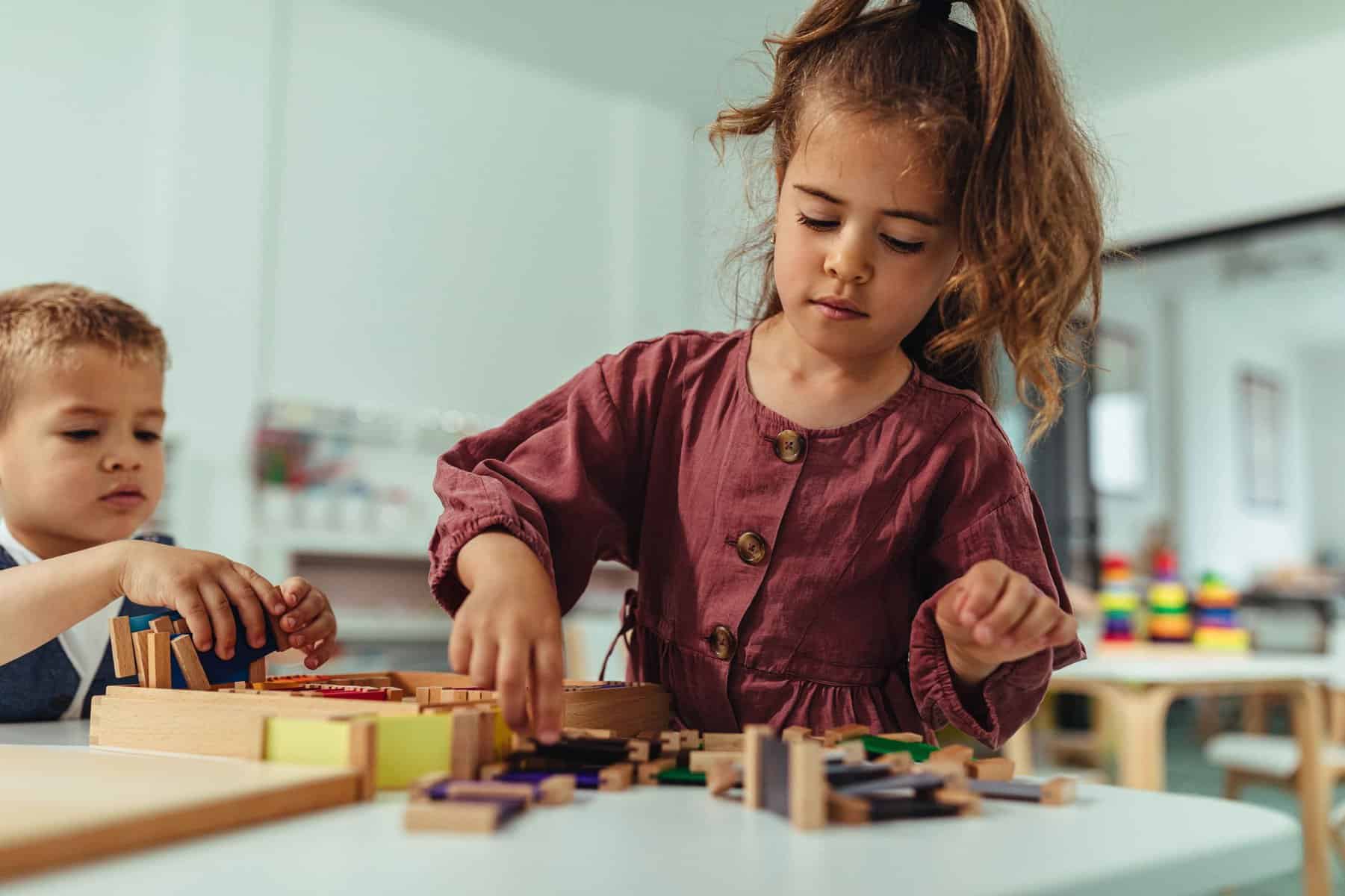 Getting creative with toys Cute little girl playing at kindergarten